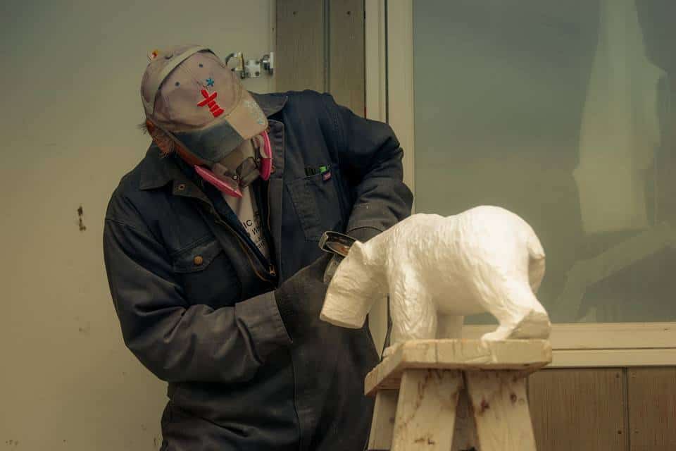 An Aivilingmiut carver, carving a polar bear
