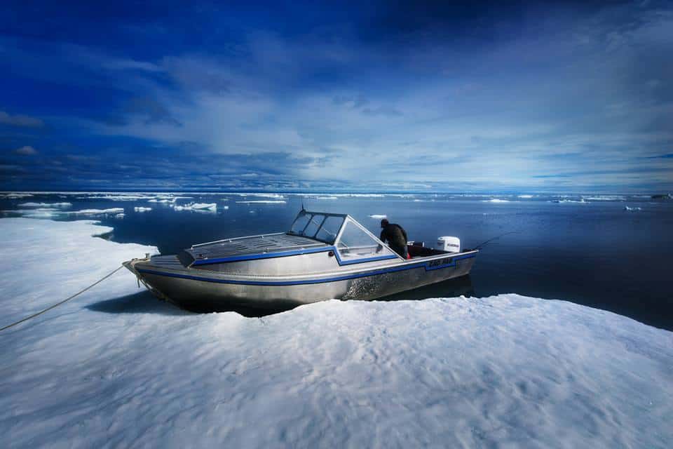 A boat tied, resting against the edge of an ice floe